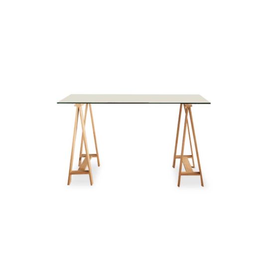 Waverley Trestle Desk, is a boss glass tabletop and metal legs finished in an oak-coloured foil.